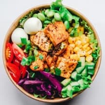 Photo of a tofu bowl with edamame, eggs, corn and vegetables